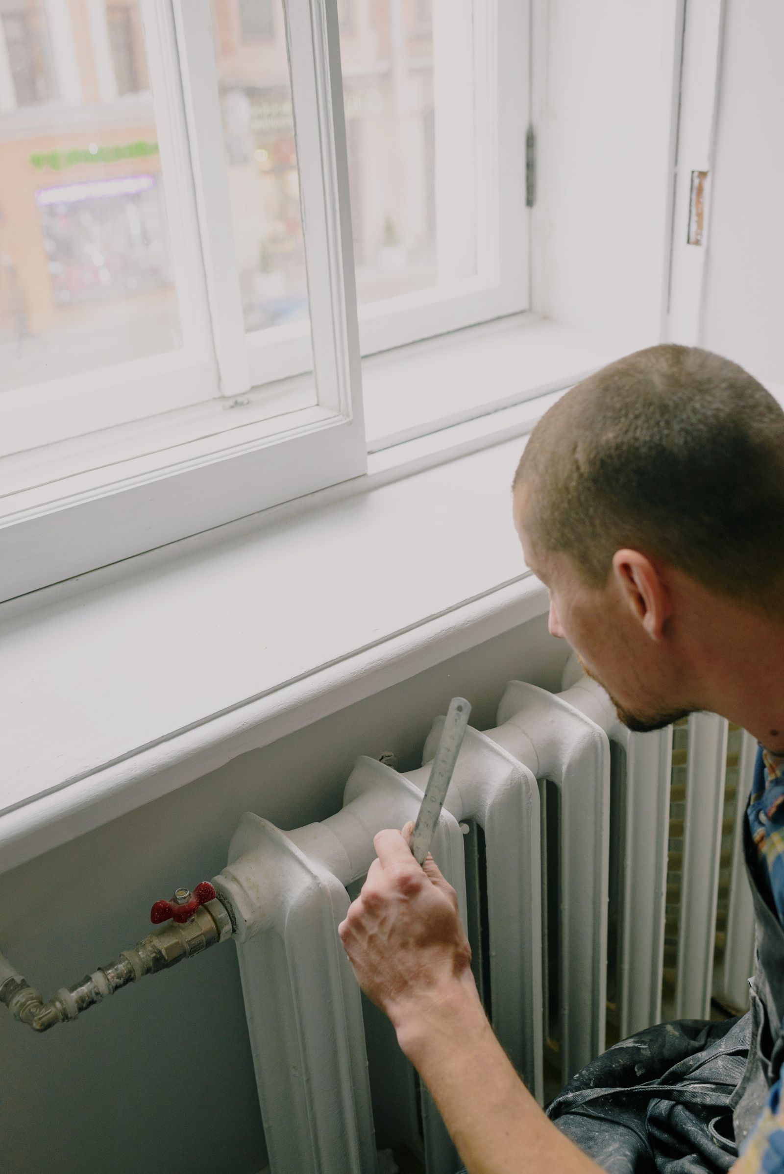 Chauffagiste intervenant sur un radiateur chez un client
