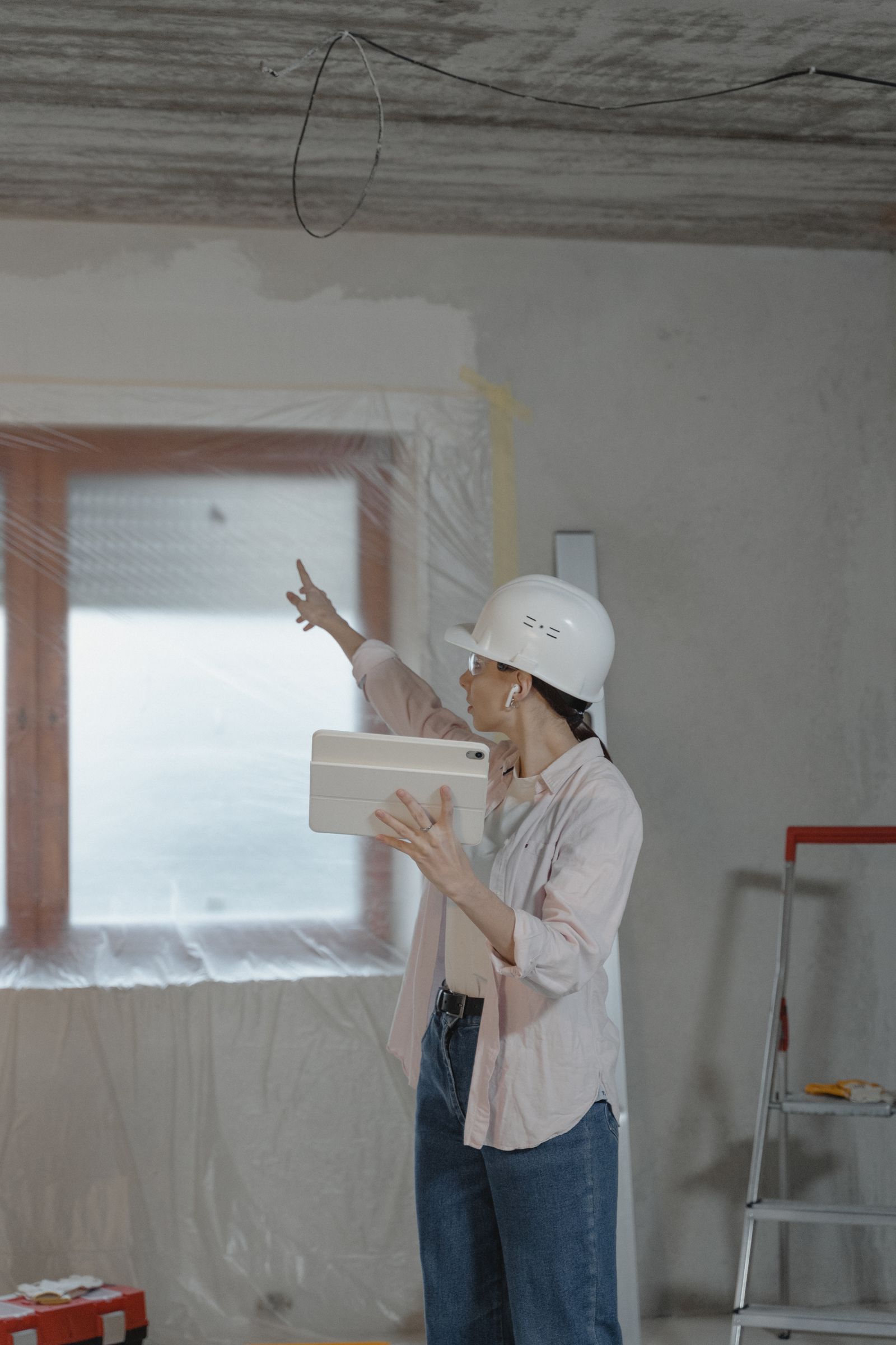 Professionnelle chiffrant un chantier de rénovation, tablette à la main